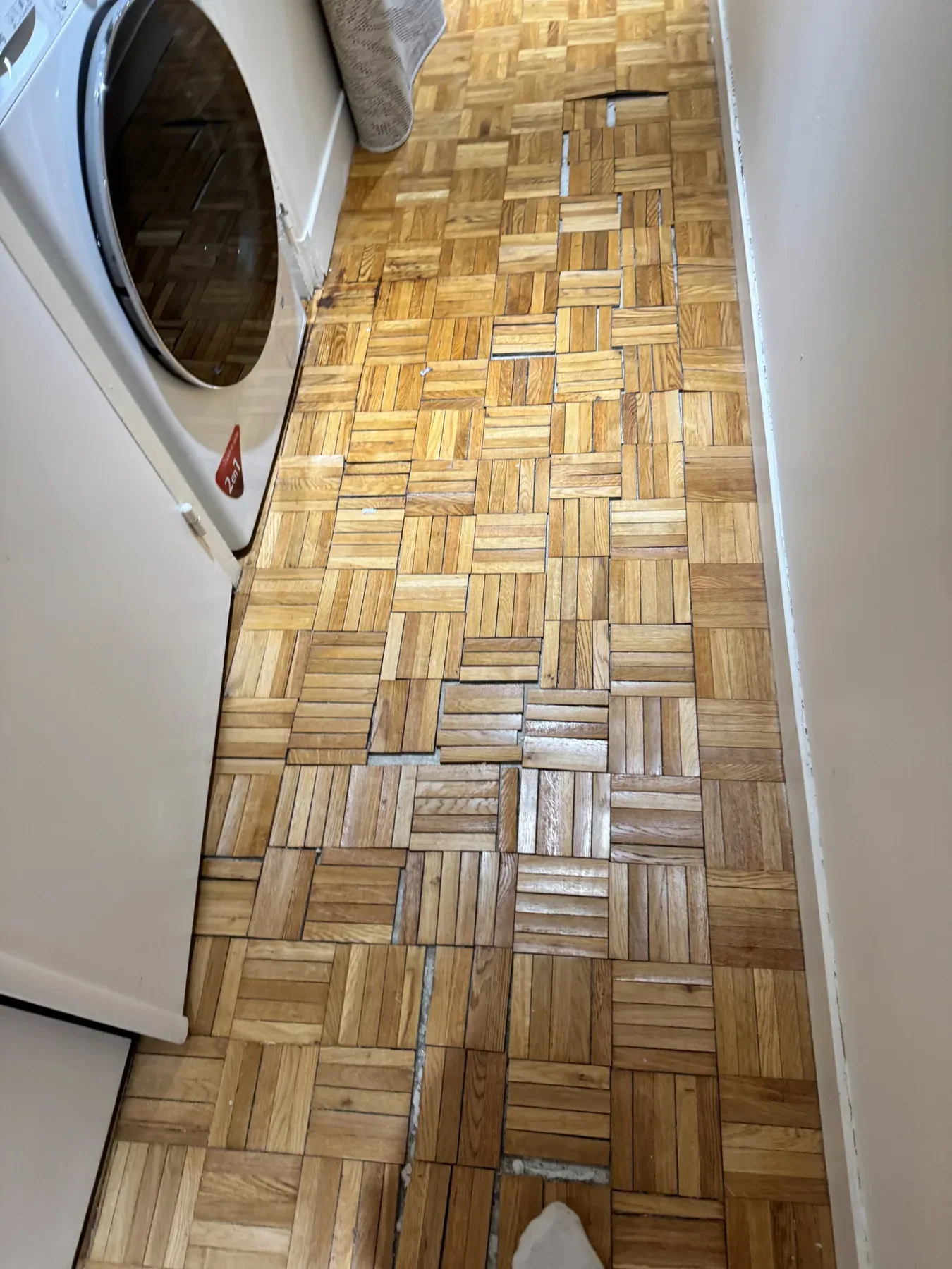 Parquet mosaïque avec des lames manquantes dans un passage.