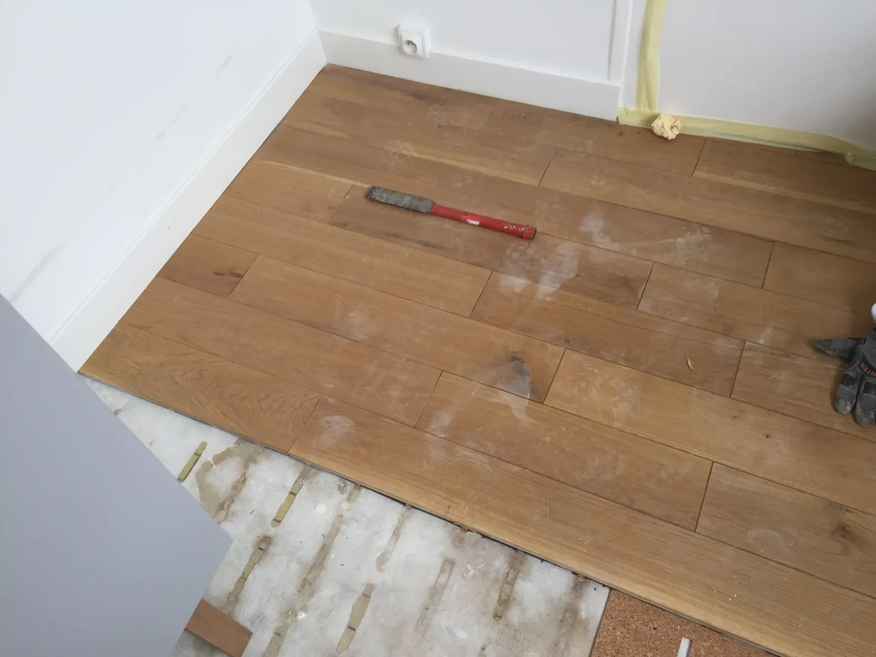 Reprise de lames de parquet en cours, avec une partie du support visible.